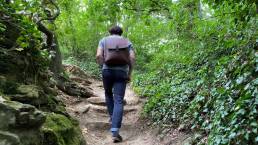 Ein Mann geht durch den Wald und trägt dabei den großen Rucksack von wrapack auf dem Rücken.