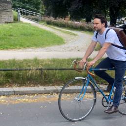 Mann auf Fahrrad fährt mit großem Rucksack von wrapack